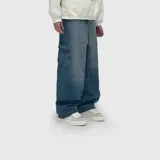 Pantalón de jean estilo cargo con corte ultra baggy, de tiro medio y pernera ancha. Presenta bolsillos laterales tipo cargo y un lavado de efecto desgastado.