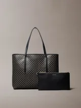 Cartera tote pequeña de Calvin Klein con estampado de monograma CK en color negro, asas de hombro dobles e incluye una cartera mini lisa a juego en el interior.