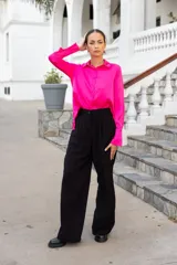 Pantalón negro de vestir con corte palazzo, tiro alto y pinzas frontales.