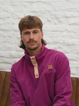 Buzo de pana color beige con cuello polo abotonado y bolsillo en el pecho.