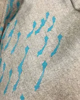 Túnica beige de gabardina de lana estampada con diseño abstracto en tonos ocre. Cuenta con cuello mao, bolsillos laterales y dos piezas a modo de bufandas que se pueden anudar de diferentes maneras.