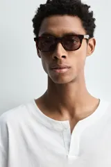 Camiseta de manga larga blanca, corte relajado, con cuello redondo y tapeta de botones (cuello panadero o henley).