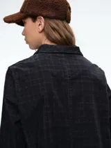 Chaqueta de corte recto y silueta cómoda, con cierre frontal de botones y bolsillos delanteros. Presenta un diseño estampado con efecto tie-dye en tonos negro y blanco.