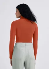 Polera de manga larga con cuello alto y diseño ajustado, confeccionada en tejido de punto liso color naranja.