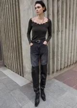 Camiseta gris de manga larga y corte entallado, con escote en V adornado con detalles de encaje negro.