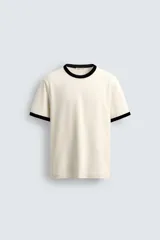 Camiseta de corte regular fit, color beige claro, con cuello redondo y bordes de mangas en color negro a contraste.