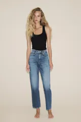 Jeans de tiro alto con diseño de cinco bolsillos, trabillas para cinturón y cierre frontal con cremallera y botón metálico.