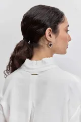 Camisa azul de manga larga con cuello alto fruncido y puños elásticos.