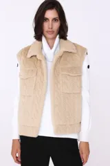 Chaleco negro de piel sintética con diseño de trenzas y cuello tipo camisa.