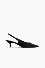 Zapatos de tacón tipo kitten heel destalonados, de color negro, con punta fina, tira elástica en el talón y forro de satén.