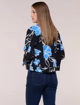 Camperita liviana de silueta entallada con estampado abstracto en tonos de azul y blanco, cuello camisero, cierre frontal con botones, bolsillos en el pecho con solapa y mangas largas.