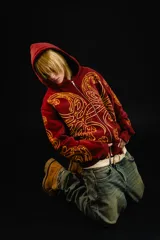 Hoodie con cierre frontal, color bordó, con estampado serigráfico en color dorado que recorre el frente y las mangas con un diseño inspirado en hojas de acanto. Cuenta con bolsillos laterales y cierre metálico.