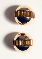 Aros tipo botón con diseño esférico en tono dorado, con una franja central decorada con cristales en tono ámbar.