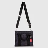 Tote bag color marrón, con diseño funcional, cierre en el compartimento principal, bolsillo interior, asas cortas y correa ajustable extraíble. Incluye un dije colgante con la letra B en color verde lima.