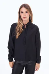 Camisa negra de corte clásico con cuello camisero y detalle de lazo ajustable en el cuello. Presenta cierre frontal con botones y mangas largas con puños abotonados.