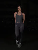 Set deportivo sin costuras color gris grafito, compuesto por una musculosas de tirantes finos cruzados en la espalda y calzas de tiro alto con control de abdomen.