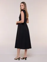 Vestido midi negro con torso de jersey sin mangas y falda de algodón, corte en la cintura con lazo de ajuste y hebilla metálica triangular.