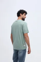 Remera de algodón blanca de manga corta y calce clásico, con estampa central vintage en tonos beige y azul.