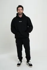 Pantalón de jogging negro con elástico en la cintura y logo 'Sosi' estampado en blanco en la pierna izquierda.