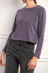 Remera color marrón de algodón peinado, corte oversize, cuello redondo y manga larga.