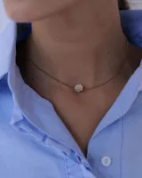 Collar de cadena tipo snake dorada con dije central en forma de flor de acrílico espejado.