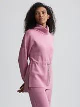 Buzo rosa de cuello alto con cordón ajustable en la cintura.