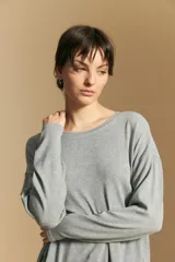 Remera de manga larga con silueta relajada y caída fluida, confeccionada en tejido suave con cuello redondo y aberturas laterales en el ruedo.