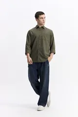 Camisa de manga larga color azul marino con textura, cuenta con cuello clásico, cierre frontal con botones y un bolsillo en el pecho.