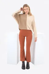 Pantalón jean acampanado color ladrillo, de tiro alto, con cierre lateral invisible, pretina ancha con costuras decorativas y un único pasacinto en la parte posterior con bordado a tono.