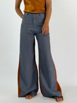 Pantalón de lino color marrón con paneles laterales en color crema y corte acampanado.