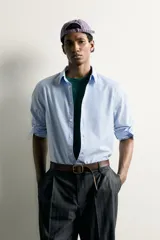 Camisa celeste de corte relaxed fit confeccionada en algodón, con cuello con botones y manga larga.