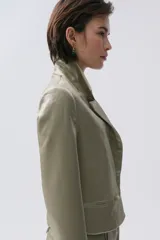 Blazer color verde oliva de tafeta metalizada, con solapas de muesca, cierre cruzado con dos botones y corte cropped.