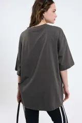 Remera oversize gris oscuro con cuello en V y mangas cortas. Presenta una estampa frontal estilo universitario con el número "09" y las inscripciones "MVD", "UY" y "PIMENTÓN ACTIVE" en tonos celestes y blancos.