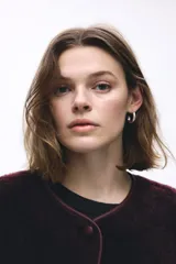 Campera de corte holgado confeccionada en sherpa suave, con escote redondo y cierre frontal de botones. Presenta hombros caídos, ribetes en tejido revestido y bolsillos laterales discretos.