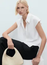 Camisa sin mangas de lyocell, color blanco, con cuello camisero y cierre frontal de botones.