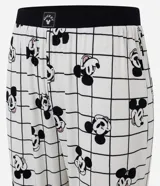 Conjunto de pijama compuesto por una remera negra de manga larga con cuello redondo en color rosa y estampa pequeña de Mickey Mouse, y un pantalón tipo jogger blanco con estampado de cuadrícula y figuras de Mickey Mouse.