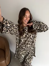 Buzo de cuello redondo y mangas largas con diseño holgado, confeccionado en tela de viscosa con textura acanalada y estampado animal print de leopardo.