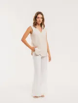 Pantalón negro de lino, tiro alto, corte palazo, con elástico en la pretina trasera, cierre delantero y broche interno. Tiene bolsillos laterales, dobladillo invisible y tajos a los costados.