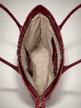 Cartera tipo tote bag de cuero vacuno color marrón oscuro, de diseño estructurado con asas largas para llevar al hombro y cierre superior. Presenta detalles de costuras decorativas y pespuntes en el frente.