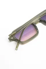 Lentes de sol con armazón rectangular de acetato color ocre translúcido y cristales degradados en tono violeta.