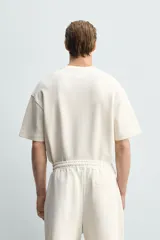 Sudadera de manga corta con corte relajado, confeccionada en tejido interlock de algodón con elasticidad y cuello redondo.