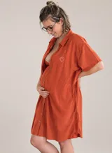 Camisa tipo vestido de lactancia y maternidad color naranja, de manga corta, corte holgado con cierre frontal de botones y pequeño bordado de corazón en el pecho.