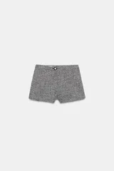 Bermudas de tiro medio confeccionadas en tejido texturizado en tono gris y negro, con cierre frontal de cremallera y botón.