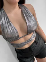 Top negro con escote halter y tiras cruzadas en el abdomen.