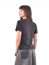 Remera blanca de manga corta con cuello redondo, destacada por apliques bordados con lentejuelas en los hombros.