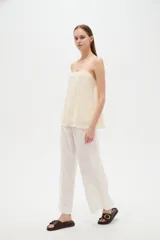 Musculosa de poliéster color marfil, con tirantes finos regulables, cuello cuadrado y diseño holgado, decorada con bordados de estrellas.