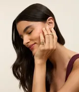 Set de tres anillos rígidos de metal con baño light gold. Incluye un anillo con cristal, un anillo liso y un anillo con detalle de hoja.