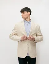 Blazer beige de medio forro confeccionado en mezcla de algodón y lino, con silueta estructurada, solapas de muesca, cierre frontal de dos botones y bolsillos con solapa.