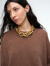 Sweater de tejido de punto en color rosa claro con motas de colores, de corte holgado, cuello redondo y mangas largas con hombros caídos.