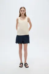 Musculosa de viscosa color beige claro, holgada, con cuello redondo y tirantes anchos formados por múltiples tiritas trenzadas.